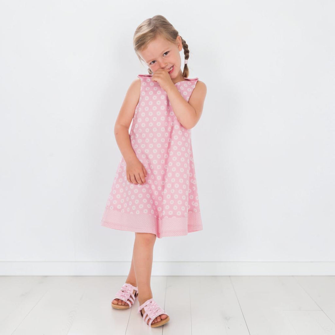 Trägerkleid PDF Schnittmuster ANTONIA – 3-in-1 Mädchenkleid 74/80–146/152 in pink mit weißen Punkten, süßes Mädchen im Kleid.