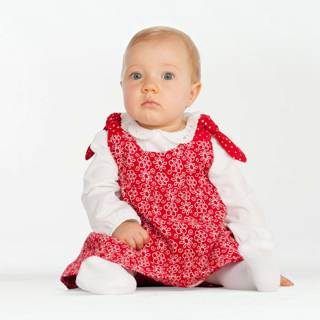 Baby Set PDF Schnittmuster BABY TWINSET – Trägerkleider & Pumphose 50/56–98/104, Baby in rotem Kleid mit Blumenmuster.