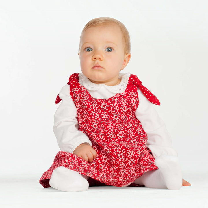 Baby Set PDF Schnittmuster BABY TWINSET – Trägerkleider & Pumphose 50/56–98/104, Baby in rotem Kleid mit Blumenmuster.
