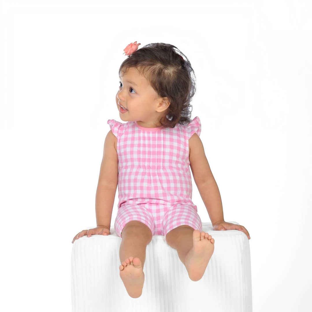 Schnittmuster Baby Overall MIA PDF auf einem süßen Kind in einem karierten Overall mit Rüschenaermeln.