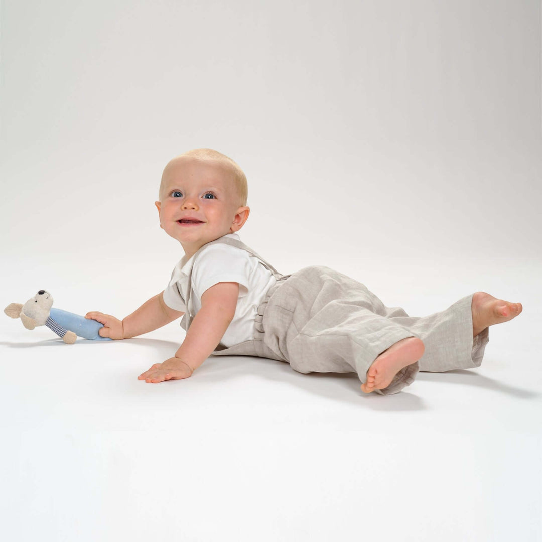 Schnittmuster Kleinkind Latzhose MAX PDF 2 in 1 – Kleinkind trägt Latzhose und spielt mit einem Plüschtier.