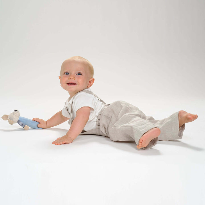 Schnittmuster Kleinkind Latzhose MAX PDF 2 in 1 – Kleinkind trägt Latzhose und spielt mit einem Plüschtier.