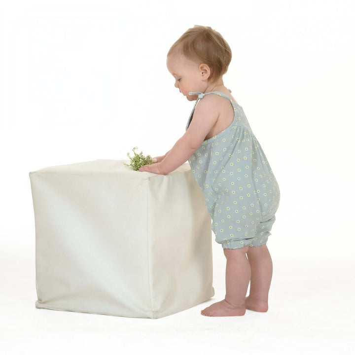 Schnittmuster Baby Mädchen Jumpsuit NELE PDF - Baby im Jumpsuit spielt mit einem Stoffwürfel.