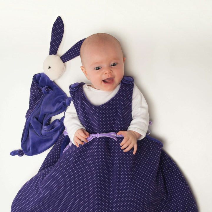 Kuscheltier PDF Schnittmuster TONDINO – Baby Schmusetuch 3-in-1 mit einem lächelnden Baby in einem lila Kleid.