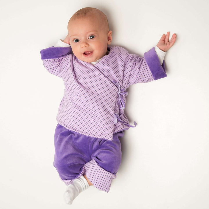 Babyjacke PDF Schnittmuster FIORINO – 3-in-1 Wickeljacke 50/56–86/92, Baby in lila gepunkteter Wickeljacke.