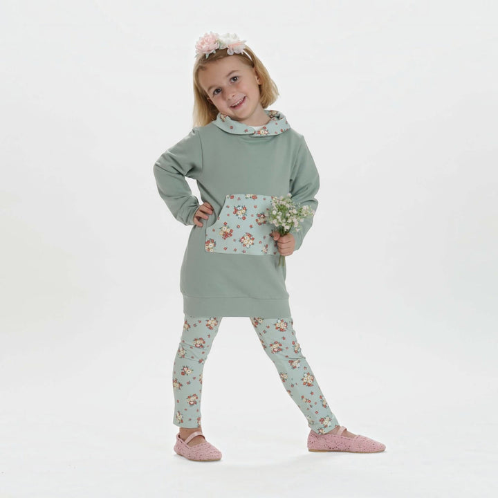 Kinder Hoodie PDF Schnittmuster ARWEN – Tunika mit Kapuze & Kragen 80/86–140/146, Mädchen im Hoodie mit floralem Design.