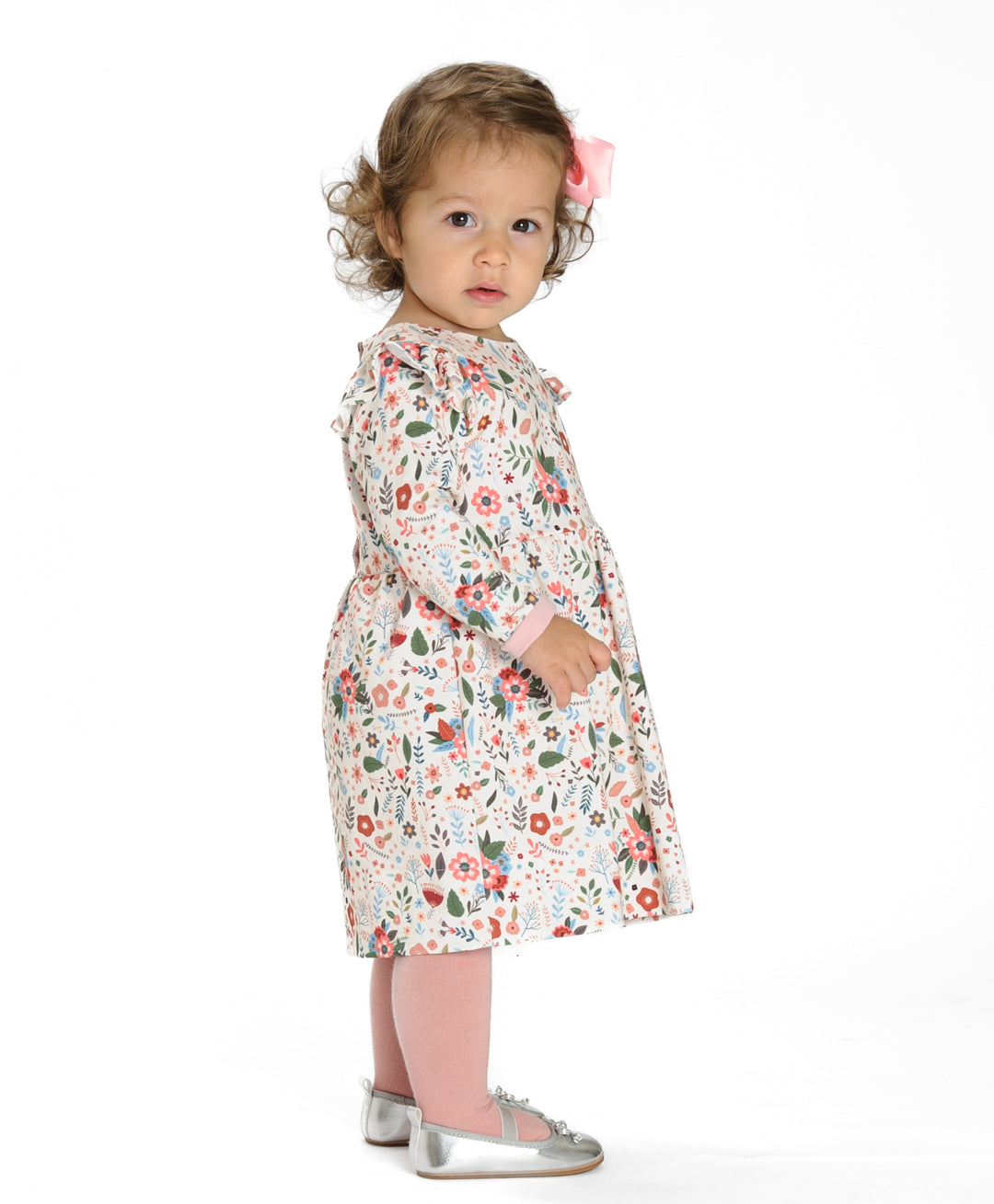 Schnittmuster Retro Kleid für Mädchen ELLA mit langen Ärmeln, gezeigt an einem Mädchen mit Blumenmuster.